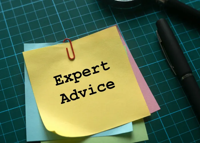 A photo containing a yellow sticky note on a green background that reads Expert Advice