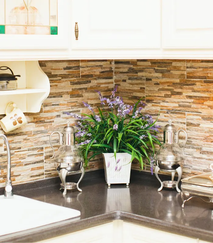 A new kitchen backsplash done with different brown, tan, and cream colored tiles