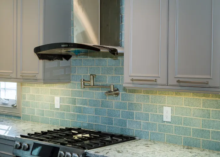 A beautiful kitchen backsplash made with green ceramic tiles